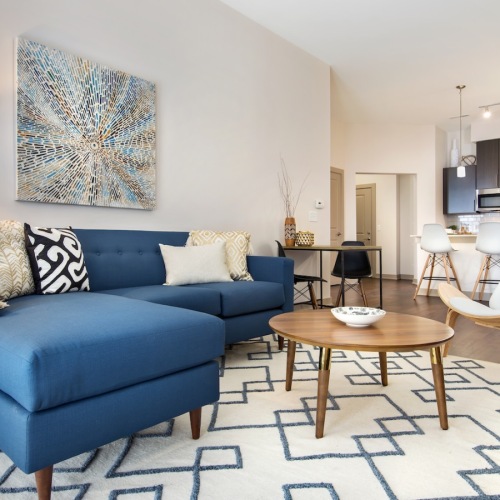 All the comforts of luxury living living room with couch and chairs and a rug