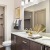 a bathroom with twin sinks and toilet and a closet