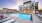 a swimming pool with loungers in front of a building