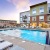 a swimming pool with loungers in front of a building