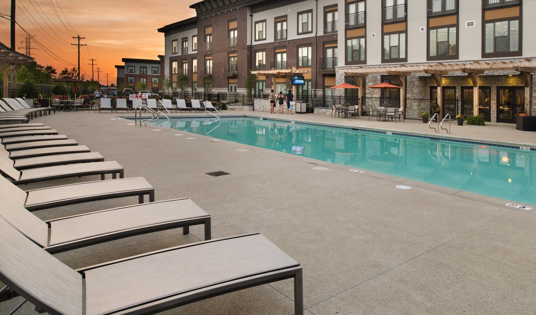 Resort-style swimming pool a swimming pool in a courtyard with lounge chairs